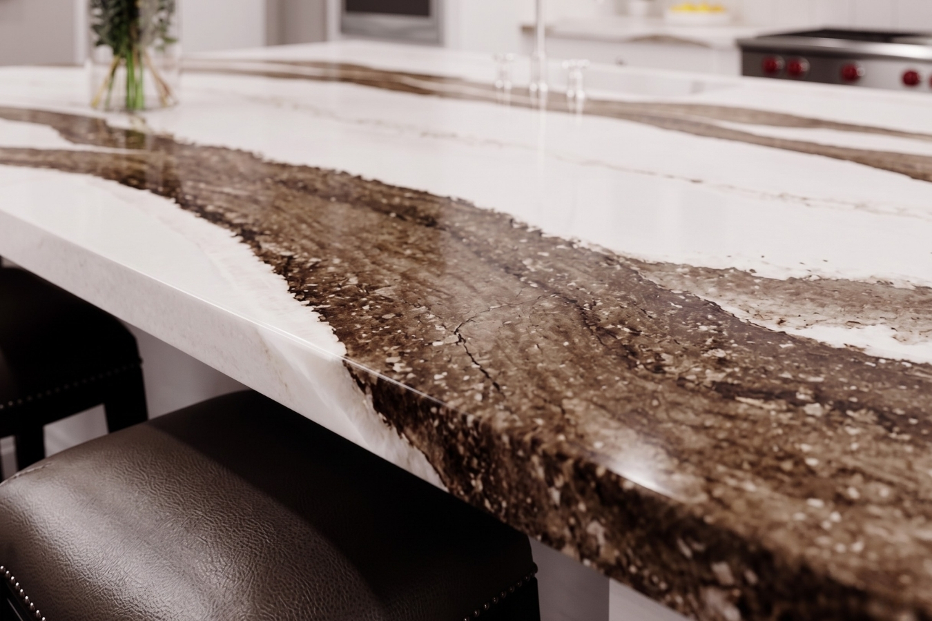 Luxury kitchen island featuring a modern quartz waterfall countertop with dramatic brown veining; precise, seamless mitered edge bonding achieved with Marktec color-matched adhesives.